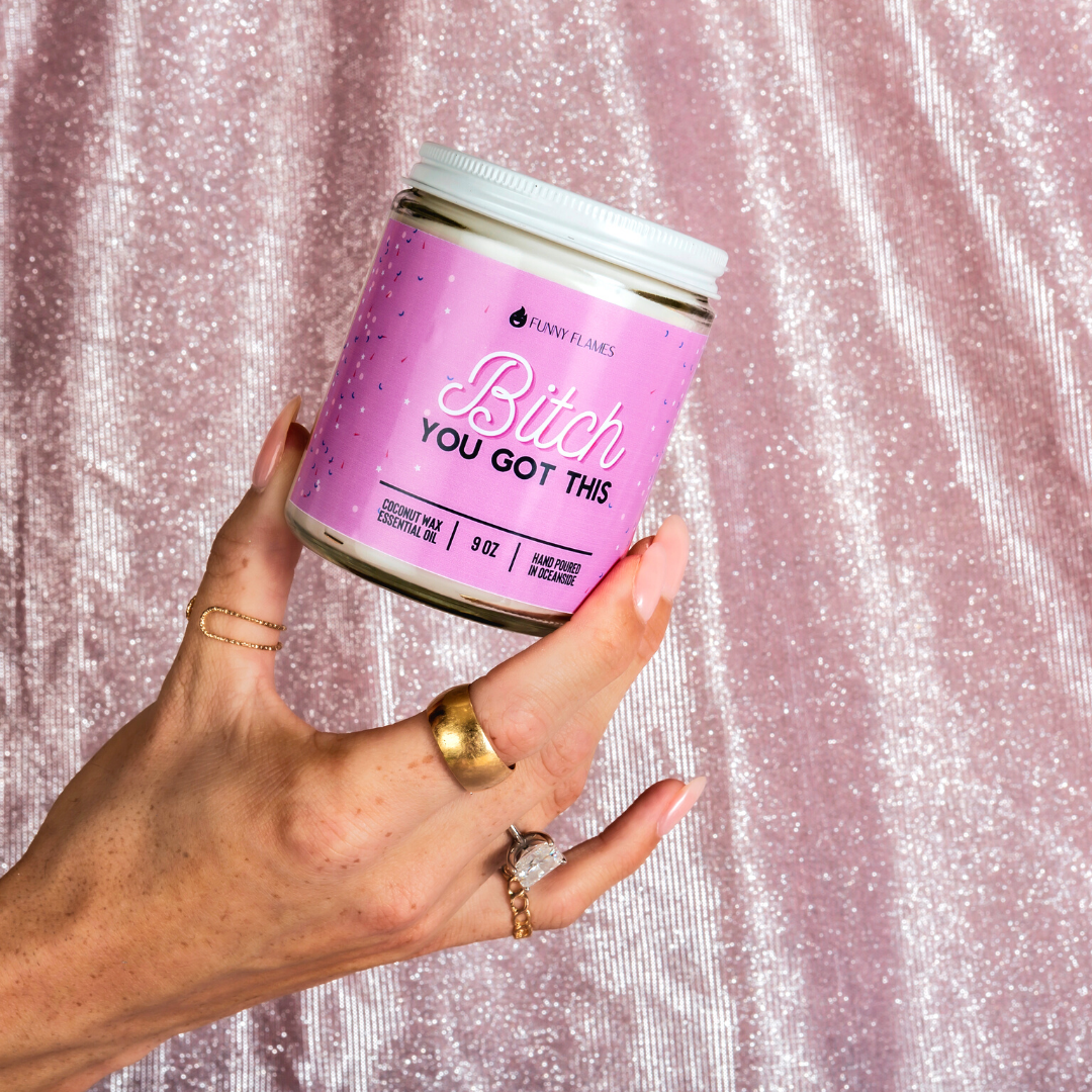 Hand holding a pink jar with text against a glittery pink background